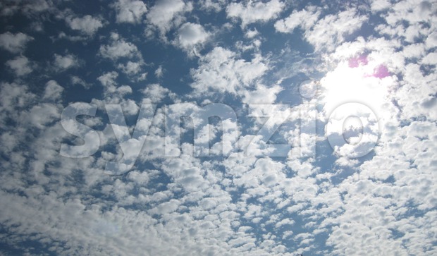 Sun and clouds at blue summer sky