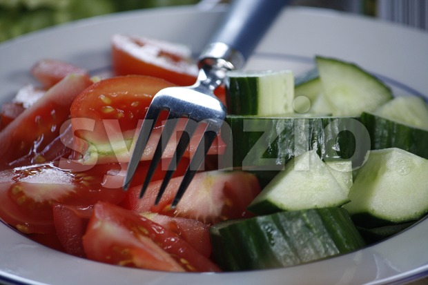 Tomatoes and Cucumber on the Plate Stock Photo